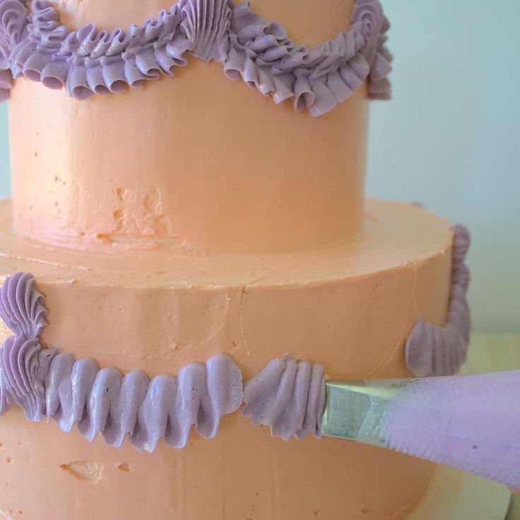 a close up of a cake with purple icing on it and a knife in the middle