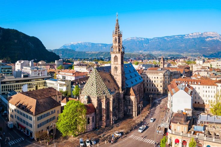 an aerial view of a city with buildings and mountains in the background