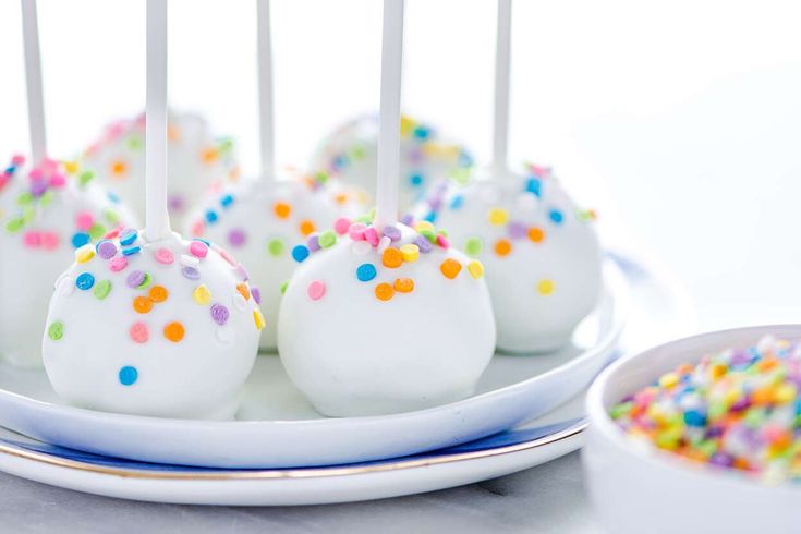 white cake pops with sprinkles on a plate