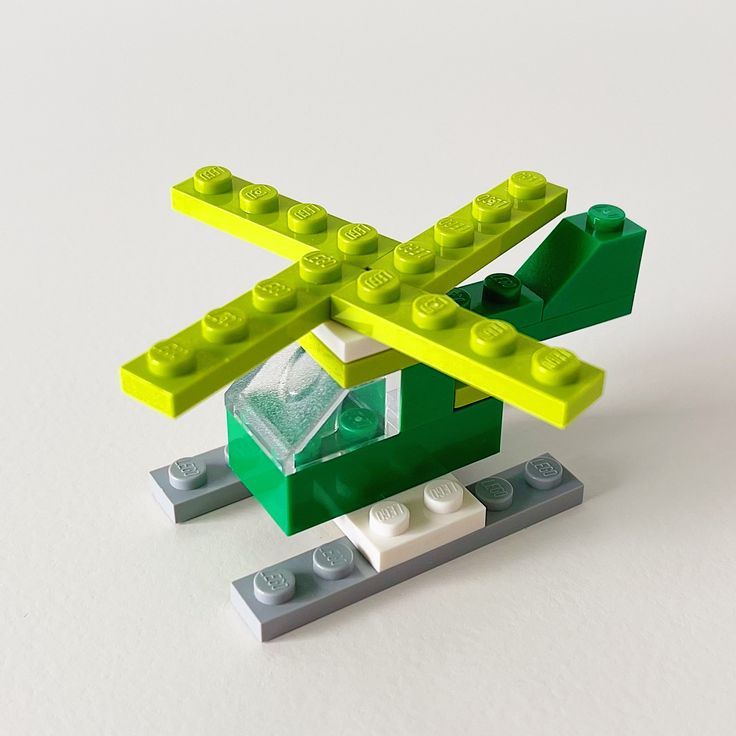 a lego model with green and yellow construction blocks on it's sides, including an arrow