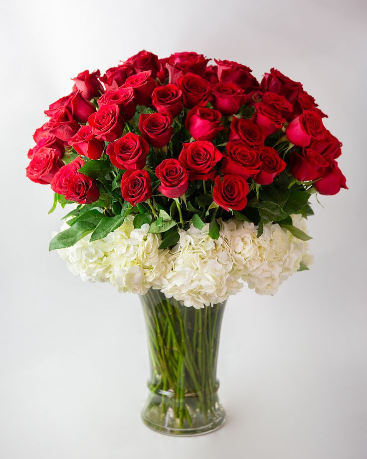 a vase filled with red and white flowers