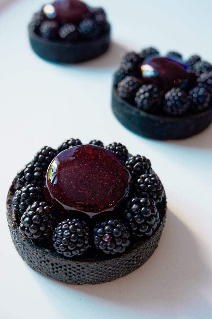 some blackberries and raspberry jam on top of each other