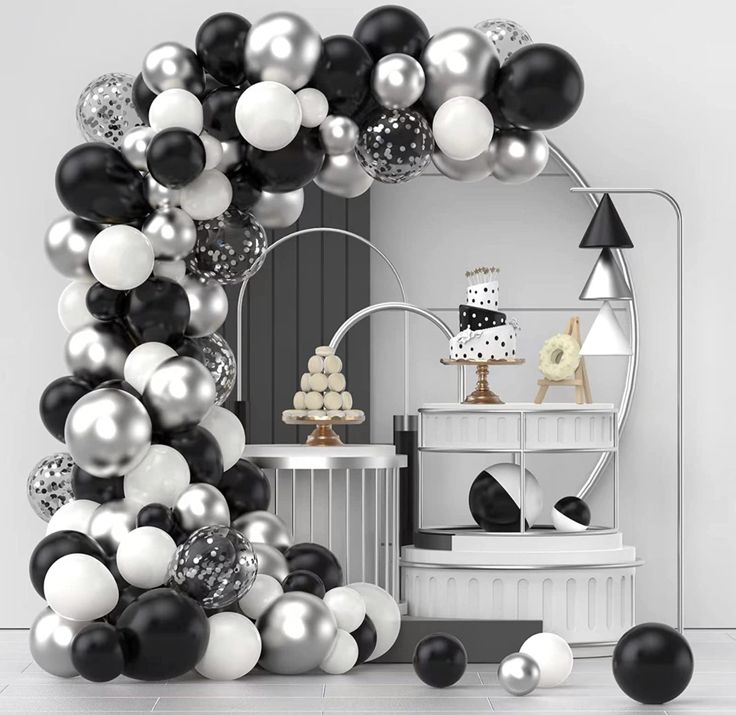 black and white balloons are in the shape of a arch