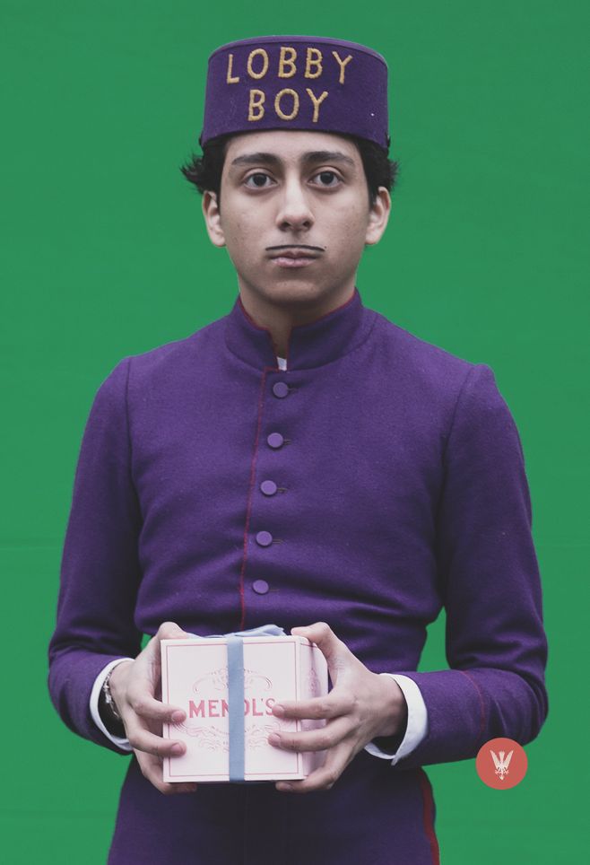 a man wearing a purple uniform and holding a box with the words lobby boy on it