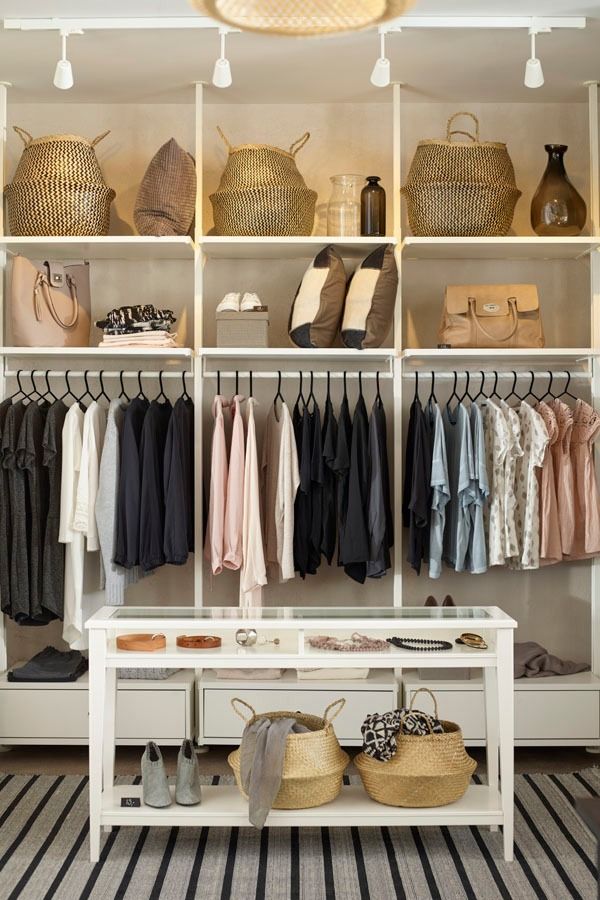 an organized closet with clothes and baskets