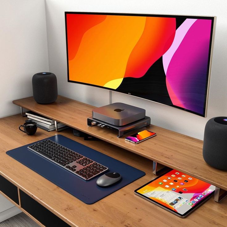 a computer desk with a monitor, keyboard and mouse on it in front of a wall