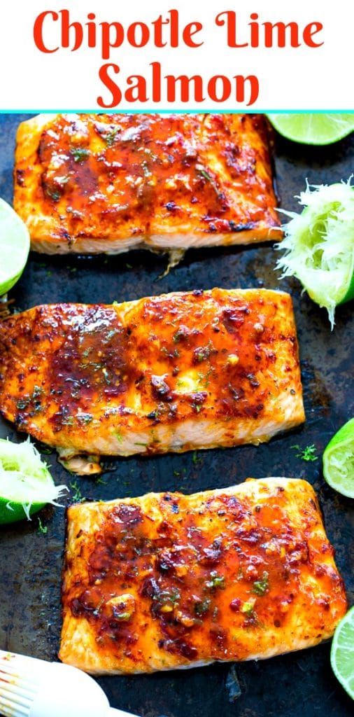 grilled salmon fillets on a baking sheet with lime wedges