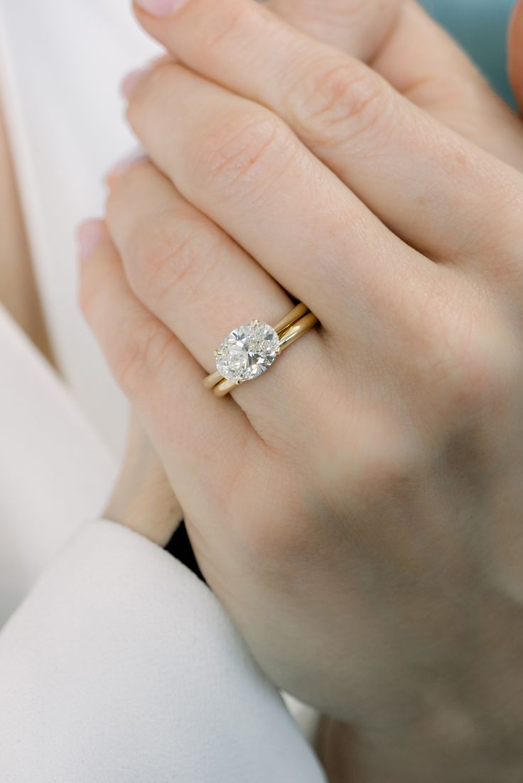 a woman's hand holding a diamond ring