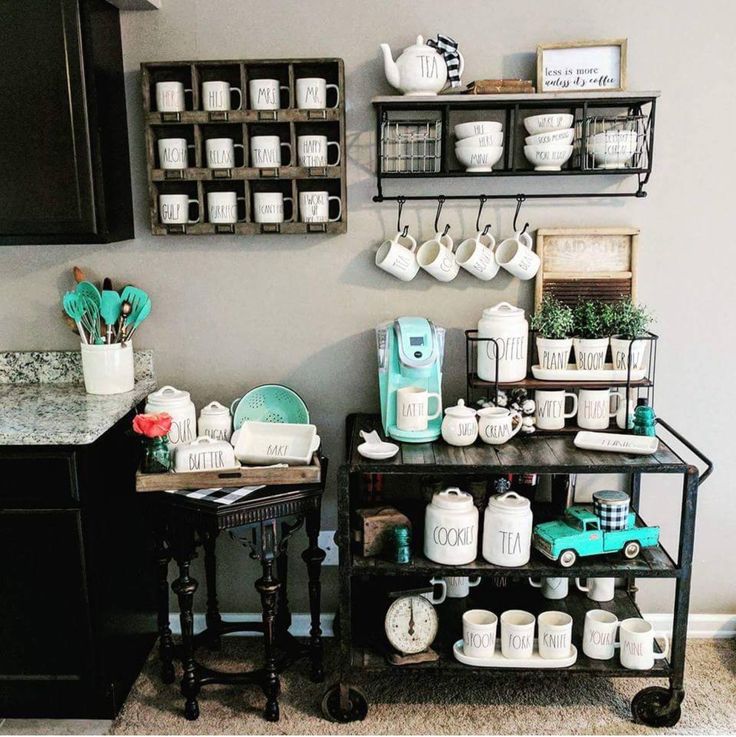 a kitchen area with two tables and shelves filled with coffee mugs, teapots and other items