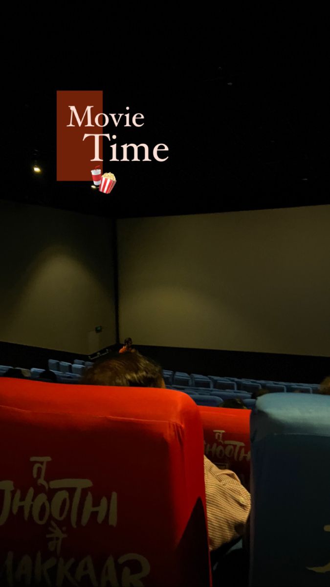 an empty movie theater with people sitting in the seats looking at something on the screen