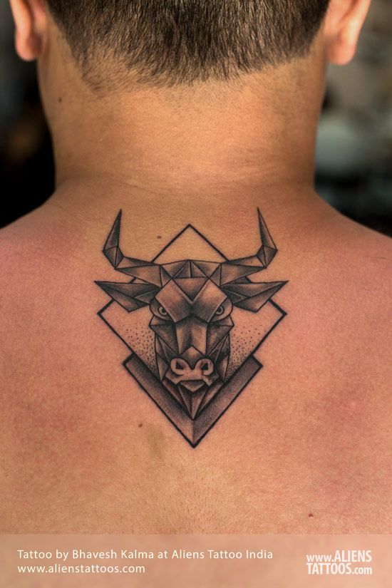 the back of a man's neck with a bull head tattoo on his chest