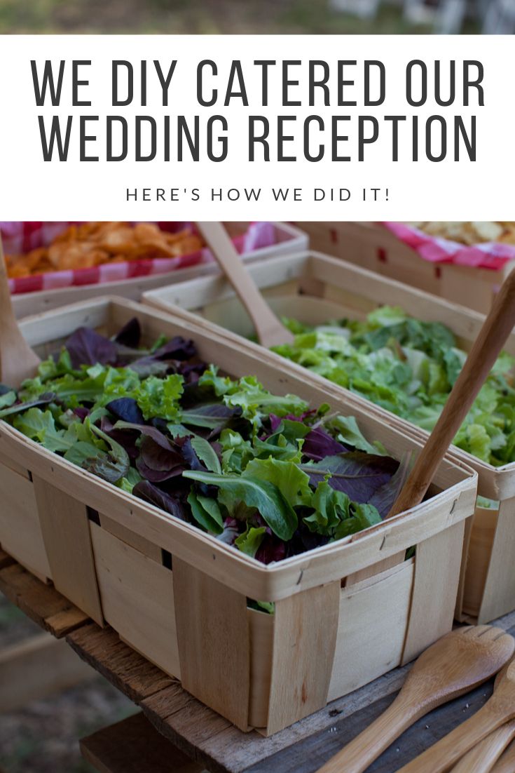 two wooden boxes filled with salads sitting on top of a table next to utensils