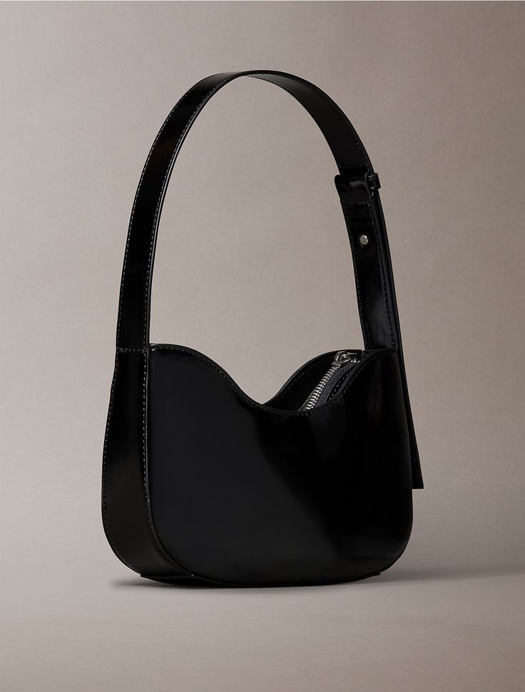 Defined with a curved silhouette, this shoulder bag is adaptable towards any outfit. Made with an adjustable shoulder strap for an ideal fit. Detailed with a zip closure and finished with a CK logo plaque at the center.  Material: 100% Polyurethane. Black Calvin Klein Shoulder Bag For Everyday, Calvin Klein Black Everyday Shoulder Bag, Everyday Black Calvin Klein Bag, Elegant Black Shoulder Bag With Metal Logo, Black Leather Calvin Klein Bag, Calvin Klein Bag, Calvin Klein, Shoulder Strap, Monogram