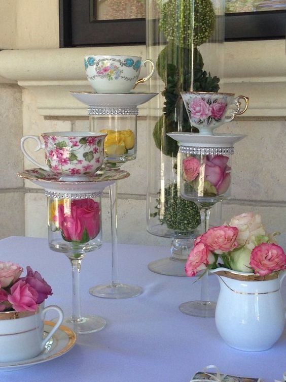 tea cups and saucers are stacked on top of each other with flowers in them