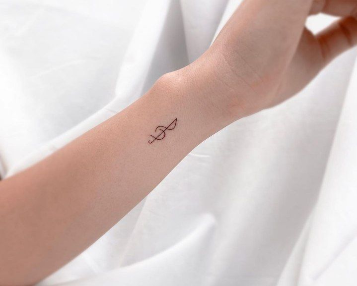 a woman's arm with a small tattoo on the left side of her wrist