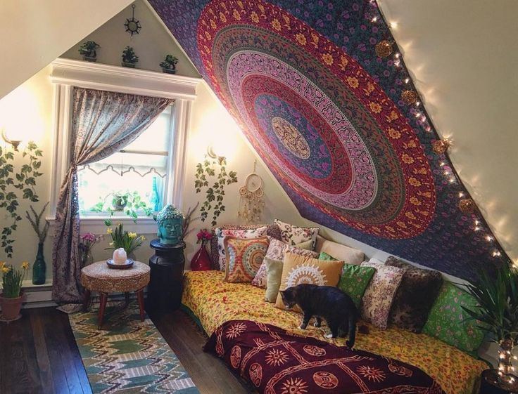 a living room filled with lots of furniture under a large tapestry hanging from the ceiling