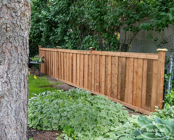 a wooden fence in the middle of a garden