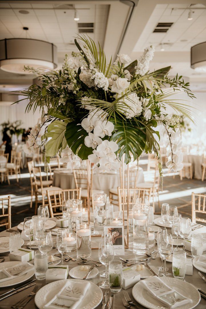 an elegant centerpiece with white flowers and greenery