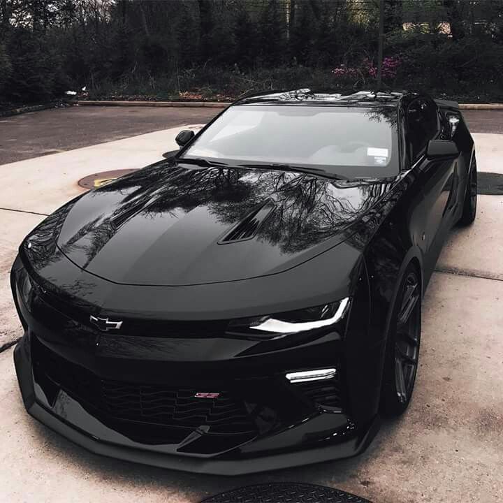 a black chevrolet camaro is parked in the driveway