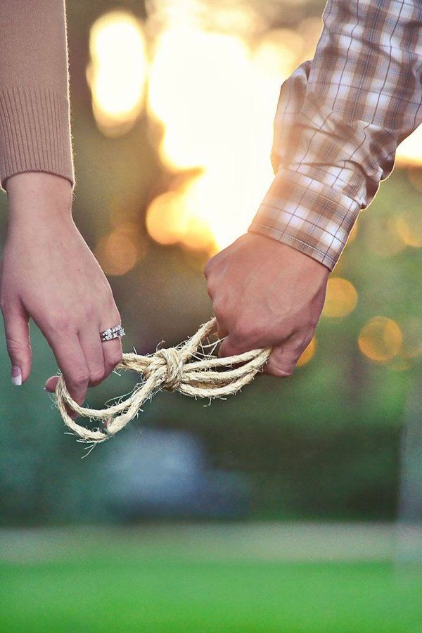 two people holding hands while tied up to each other