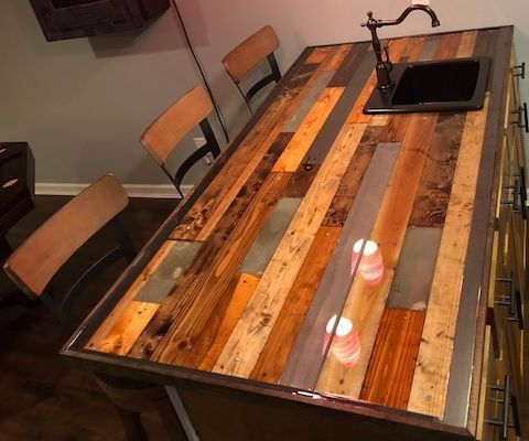 a kitchen table made out of pallet wood and metal with two cups on it