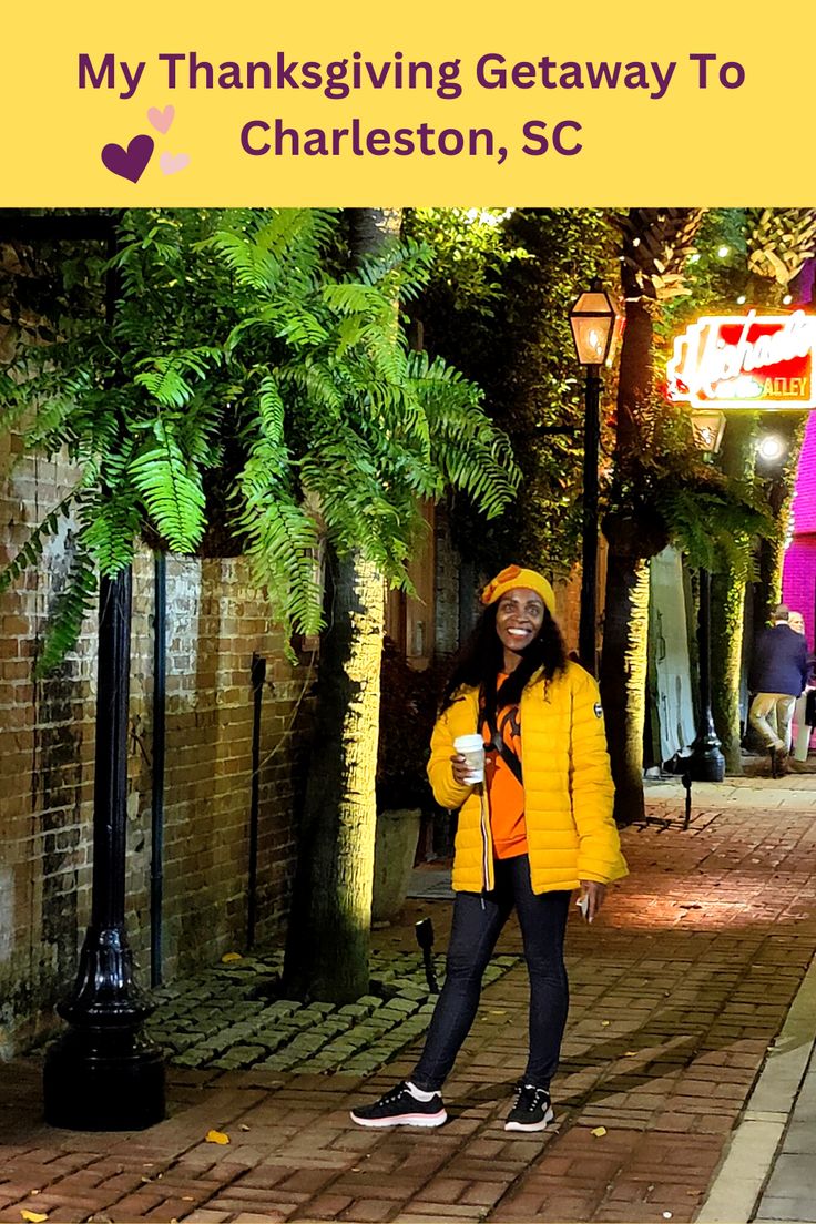 a woman standing in the middle of a street holding a coffee cup and wearing a yellow jacket