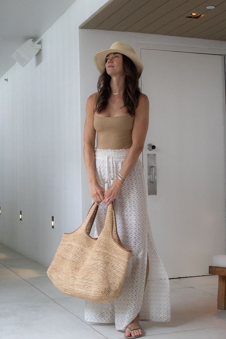 Introducing our newest addition to the Anya & Niki collection: The Biscayne Straw Bag. Expertly hand crafted with crocheted raffia, this extra large bag features luxurious tan saddle leather trim and a branded luggage tag for a touch of style. Designed for the modern traveler, it deconstructs easily to fold flat, making it perfect for packing. The wide straps ensure comfortable wear over your shoulder or for carrying like a tote. Whether you're exploring a new city or heading to the beach. Embra Chic Beige Crochet Bag With Woven Leather Details, Chic Beige Crochet Bag With Woven Leather, Chic Travel Hobo Bag With Braided Handles, Chic Crochet Tote Bag With Braided Handles, Elegant Woven Leather Beach Bag For Travel, Chic Woven Leather Tote Beach Bag, Brown Straw Tote Bag For Day Out, Natural Woven Leather Bag For Day Out, Chic Natural Hobo Bag For Travel