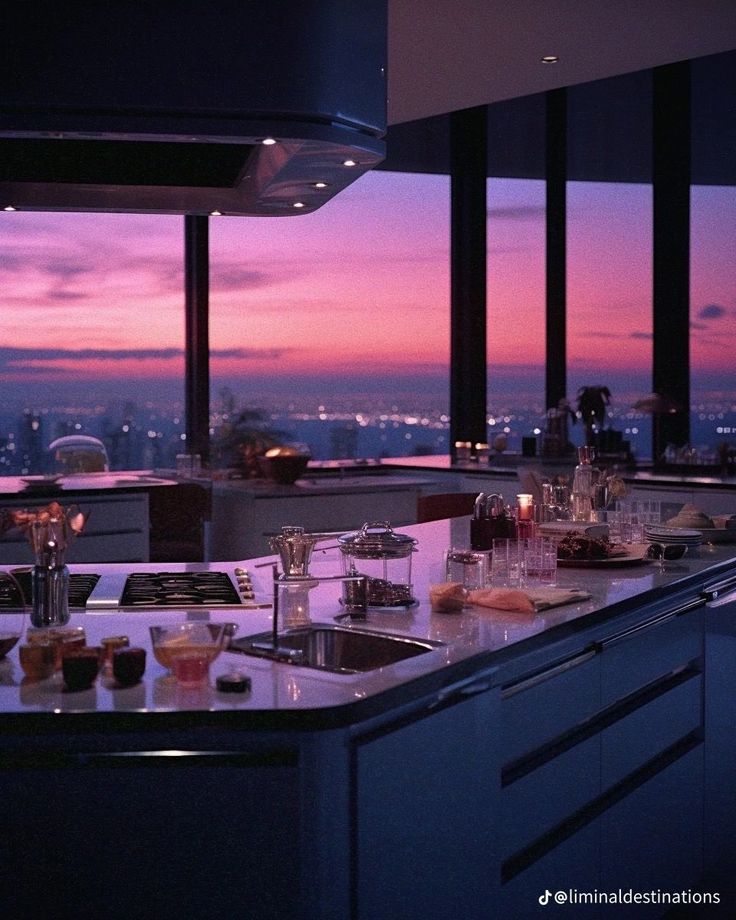 the kitchen counter is covered with dishes and glasses as the sun sets in the distance