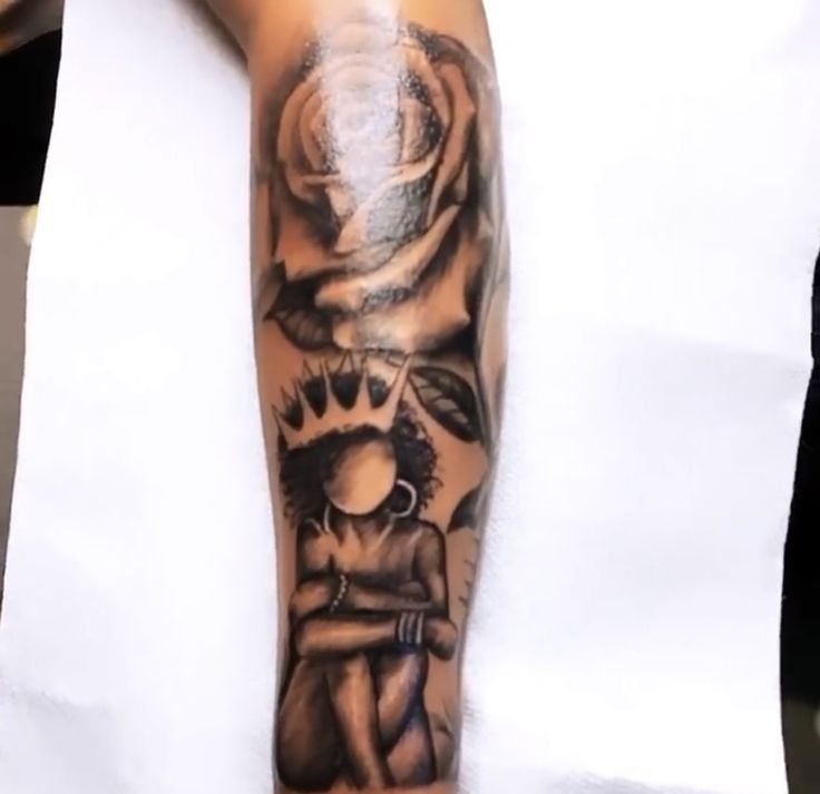 a man's arm with tattoos on it and a rose in the middle is shown