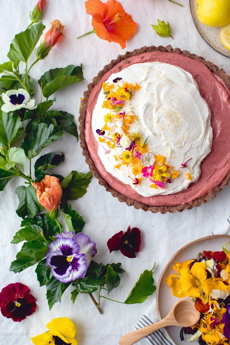 there is a pie on the table with flowers around it