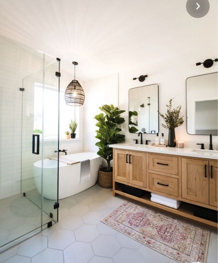 a bathroom with two sinks, a bathtub and a large mirror on the wall