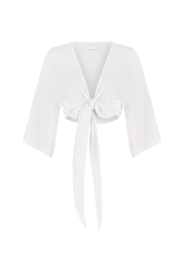 Get lost in the romance of the Bali Wrap Top White: a bold front tie style that exudes the essence of lounging in paradise. A voluptuous front tie allows for custom wear and wide sleeves keep your look breezy and light. Choose between a soft crinkled cotton or a luxe striped cotton—or get them both.  V-neckline Front tie closure Wide sleeves 100% Turkish cotton One size fits most 100% Turkish Cotton Wash in a laundry bag on a delicate or gentle cycle, lay flat to dry or tumble dry, no heat, do not bleach and cool iron if necessary. Tied V-neck Tops For Vacation, Chic V-neck Wrap Top For Beach, Spring Beach Tops With Tie Waist, Chic Tops With Tie Waist For Vacation, Chic Tie Waist Tops For Vacation, Chic Beach Tops With Drawstring Tie, Vacation Tops With Tie Waist, Elegant Vacation Top With Tie Back, Summer Loungewear Tops With Tie Waist