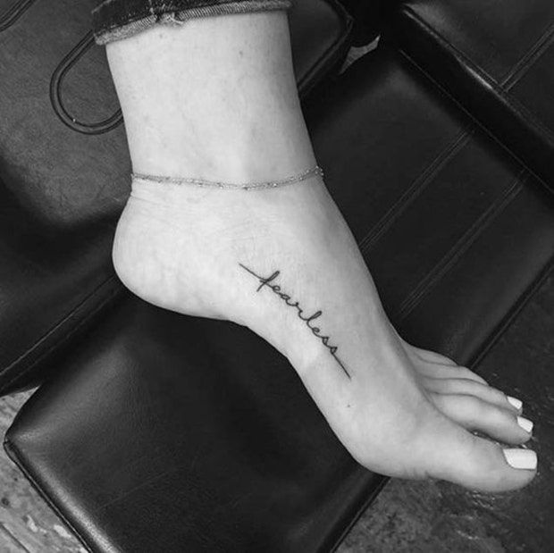 a woman's foot with the word faith tattooed on it