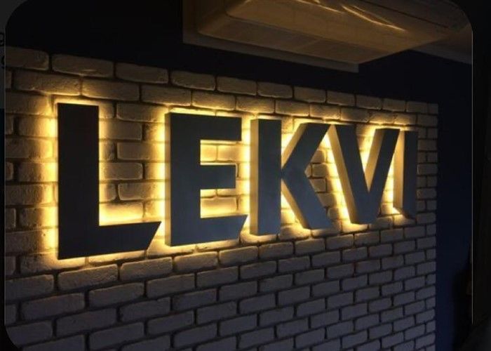 a brick wall with illuminated letters that spell out the word lekv on it