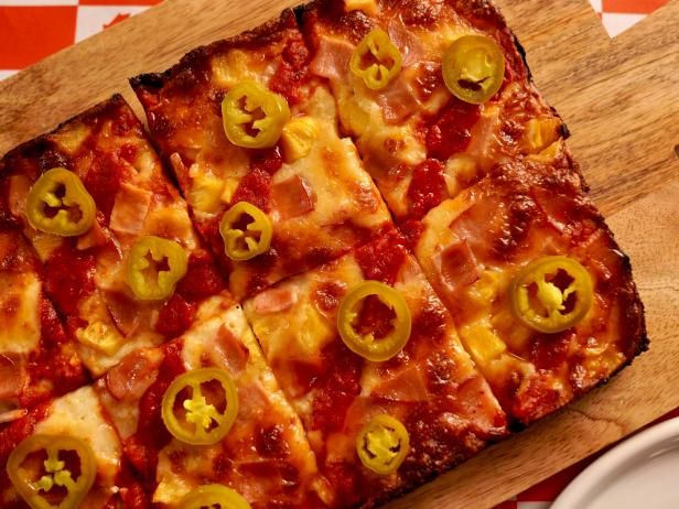 sliced pizza with peppers and cheese on wooden cutting board