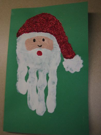 a handprinted santa clause is on a green paper with red sequins