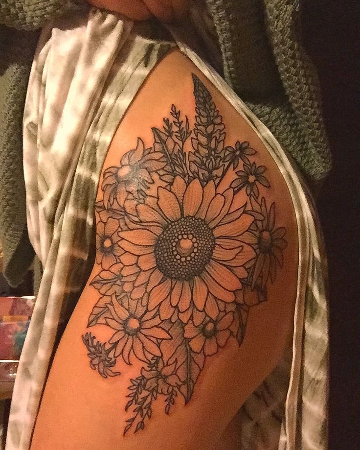 a sunflower tattoo on the back of a woman's thigh