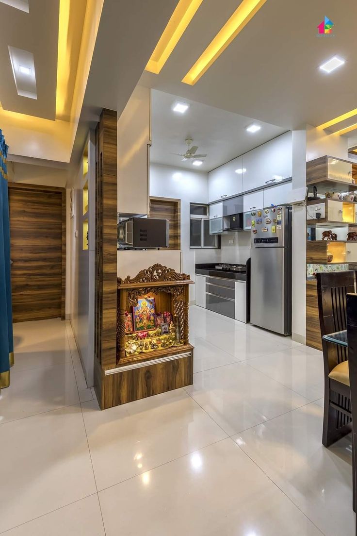 an open kitchen and dining area with a fireplace in the center, surrounded by white tile flooring