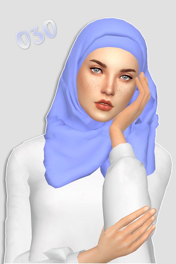 a woman wearing a blue hijab and holding her hand to her face