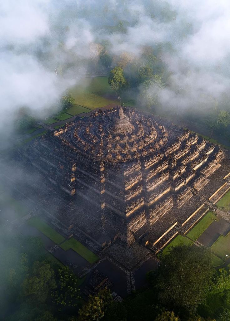 an aerial view of a temple surrounded by clouds