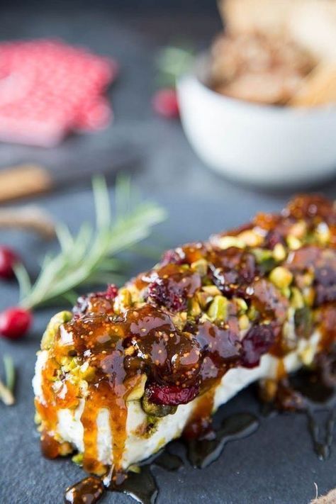 a piece of food that is sitting on a plate with sauce and other foods in the background