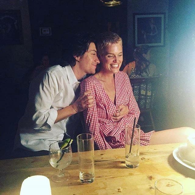 a man and woman sitting at a table in front of a cake with candles on it