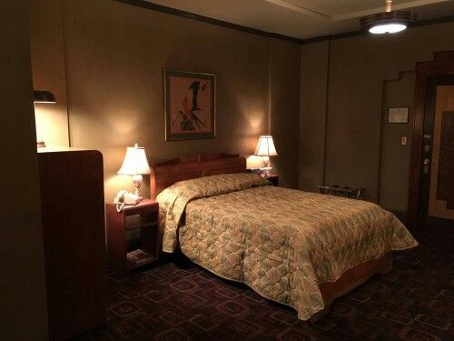 a bed room with a neatly made bed and two lamps