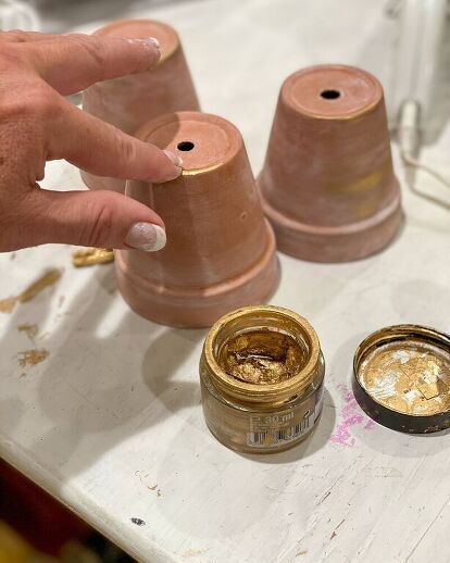 a hand is touching the top of two spools of thread on a table