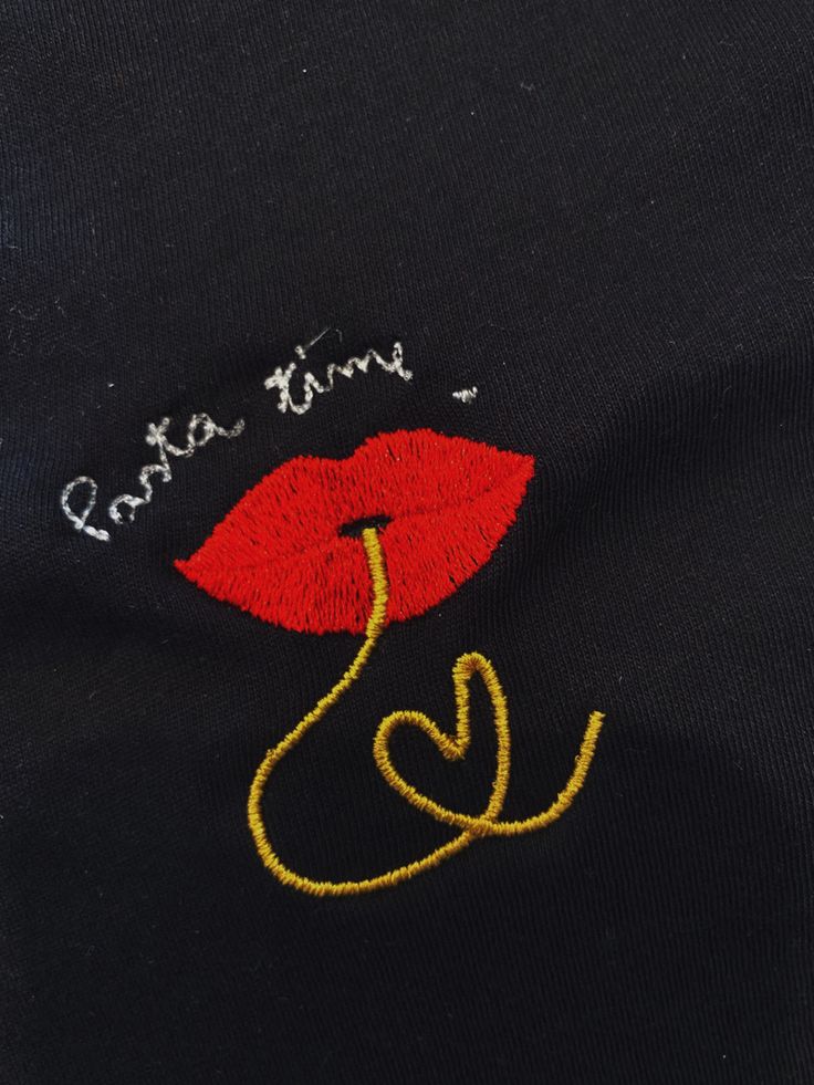 a close up of a black shirt with red lipstick on it