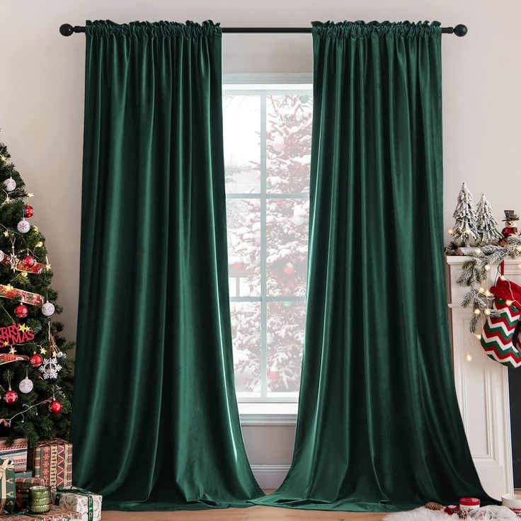 a living room decorated for christmas with green curtains and presents in front of the window