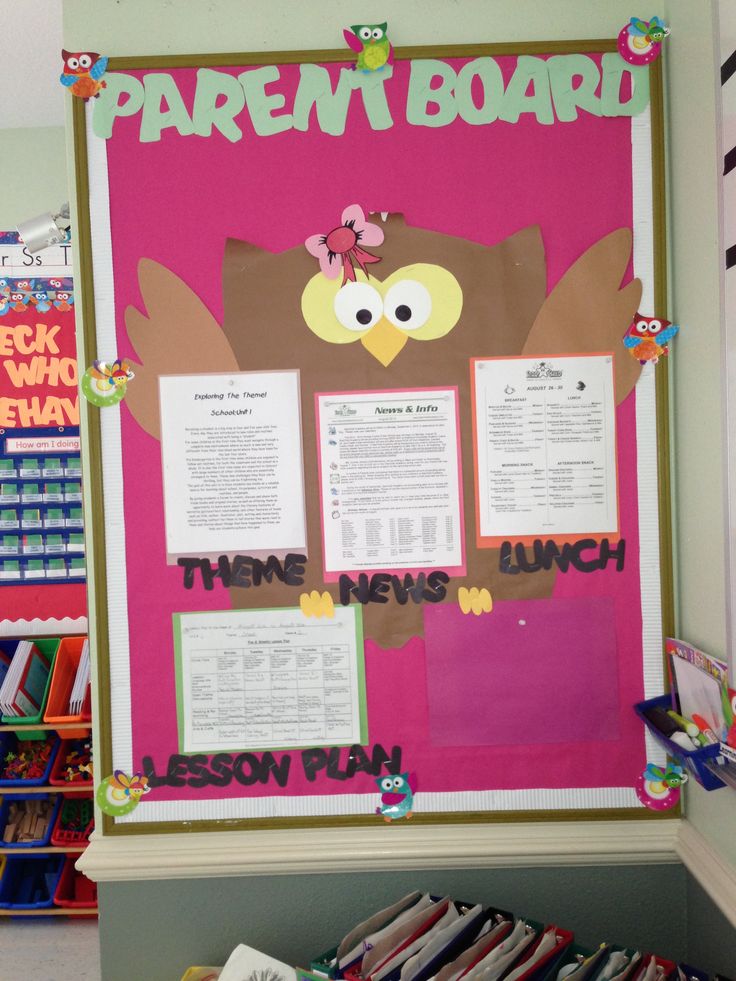 a bulletin board with an owl on it in the middle of a classroom room filled with children's books