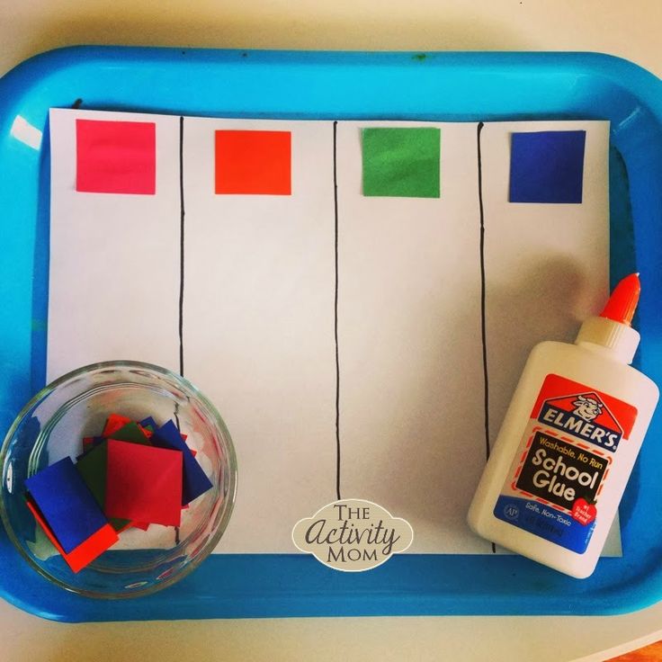 a blue tray with some legos on top of it and a bottle of glue next to it