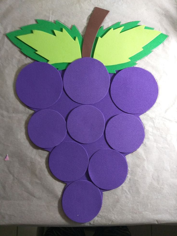 grapes cut out from paper on top of a table