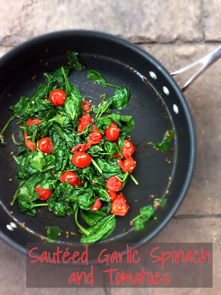 a pan filled with spinach and tomatoes